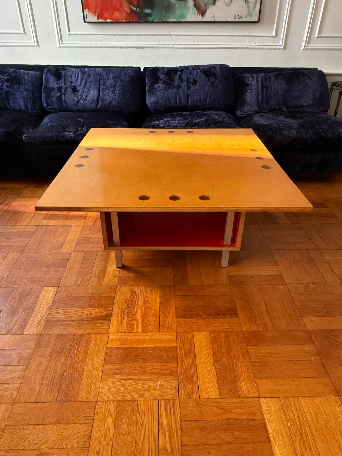 handmade modernist plywood coffee table with aluminum legs and red box underneath