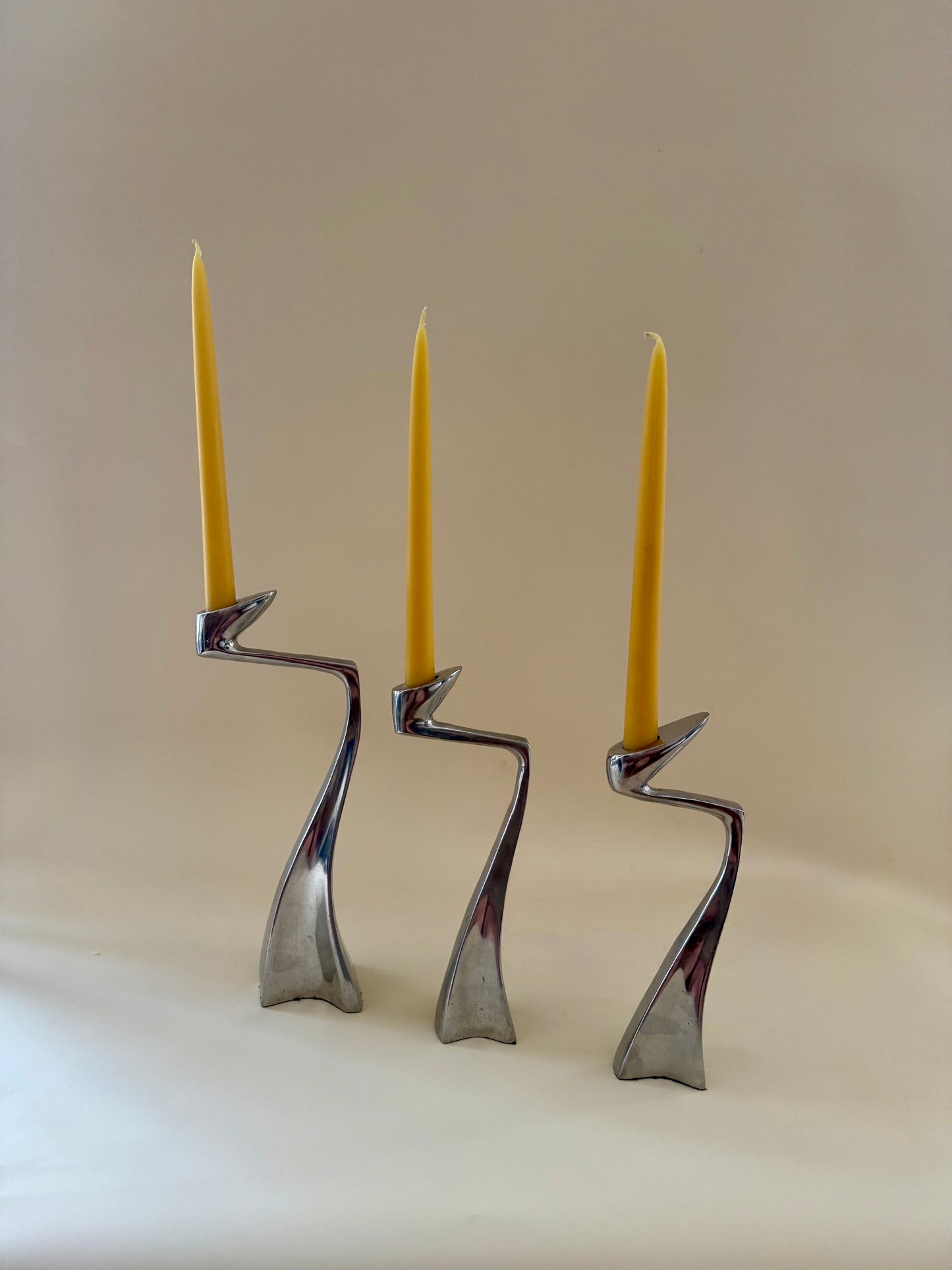 1980s set of three aluminum "swan" candlestick holders designed by Matthew Hilton